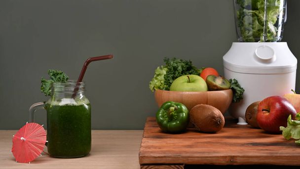 Здоровый зеленый фруктовый коктейль и ингредиенты на деревянном столе. Вегетарианское питание. - Фото, изображение