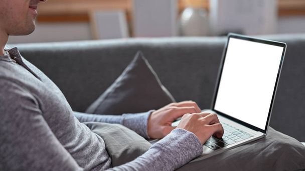 Man lying on sofa and surfing internet with laptop computer. - Valokuva, kuva