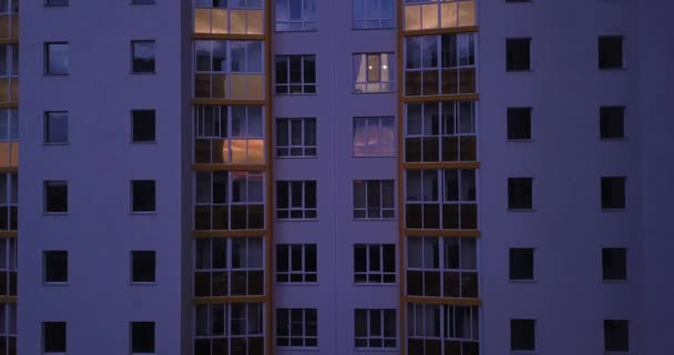 Вид беспилотника на красочный фасад современного жилого дома, окна и балконы. Съемки высотного здания в ночное время. - Кадры, видео