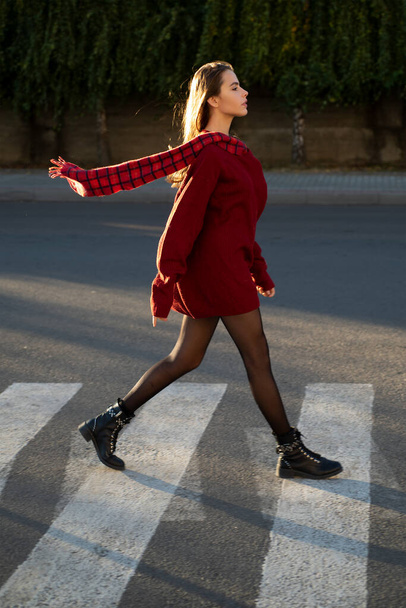 Beautiful woman walking on crosswalk in fashionable summer spring clothes outdoors. Female stylish model walking city street. Summer trend, fashion outfit. - Fotografie, Obrázek