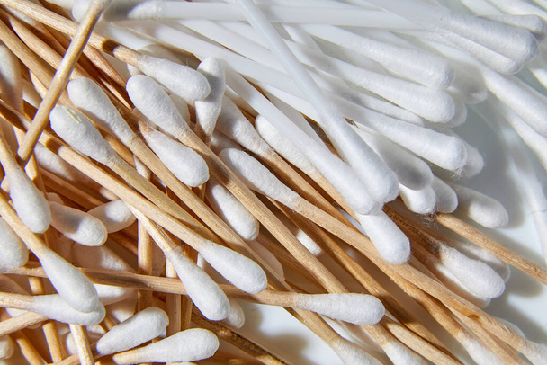 Bambú de madera ecológico y hisopos de algodón de plástico, palos para limpiar las orejas sobre fondo blanco, espacio para copiar. - Foto, imagen