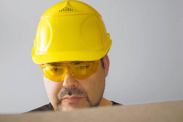 Builder man wearing yellow  helmet with blueprint  - Foto, Imagem