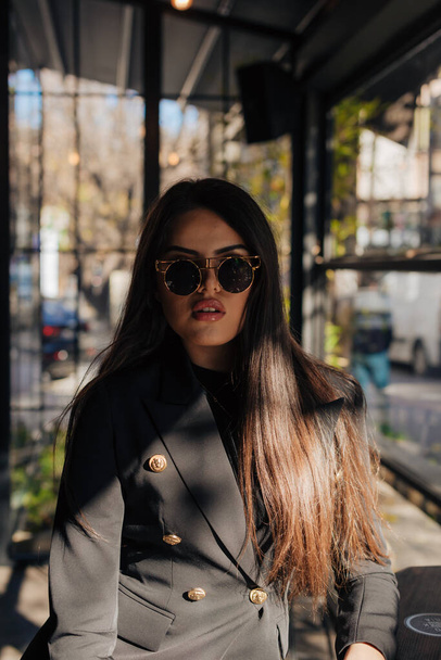 Portrait d'une femme d'affaires attrayante portant des lunettes de soleil. - Photo, image