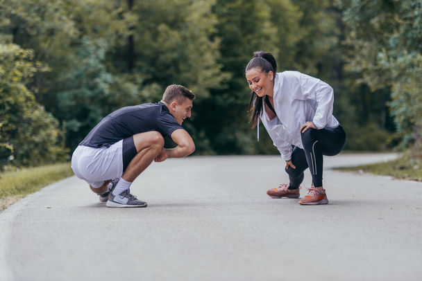 Atletas masculinos y femeninos preparándose para un maratón, correr, hacer ejercicio. concepto de estilo de vida saludable. - Foto, imagen