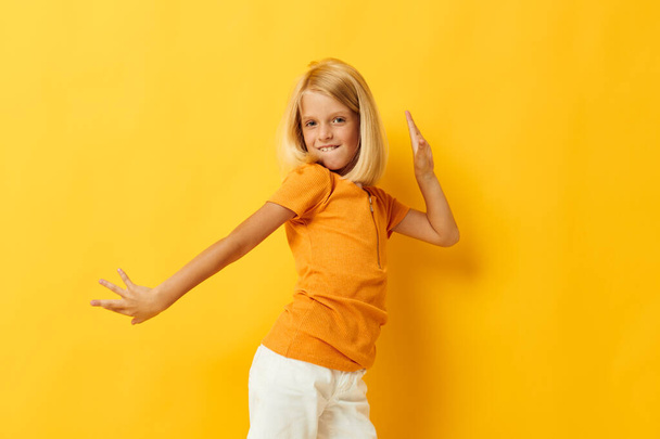 Little girl smile hand gestures posing casual wear fun yellow background unaltered - Foto, Imagem