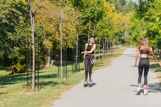 Imagen completa de las mujeres deportistas sexy patinaje sobre ruedas en el parque - Foto, Imagen