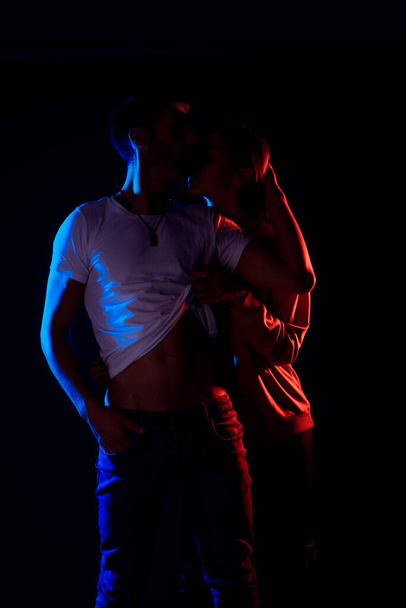 Sensual loving man and woman posing against a black background - Фото, зображення
