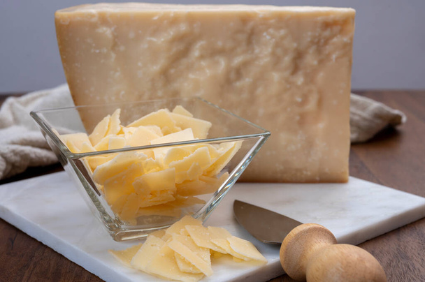 Νιφάδες παρμεζάνας, ιταλικό τυρί παρμεζάνα από την περιοχή Reggio Emilia, κοντά. - Φωτογραφία, εικόνα