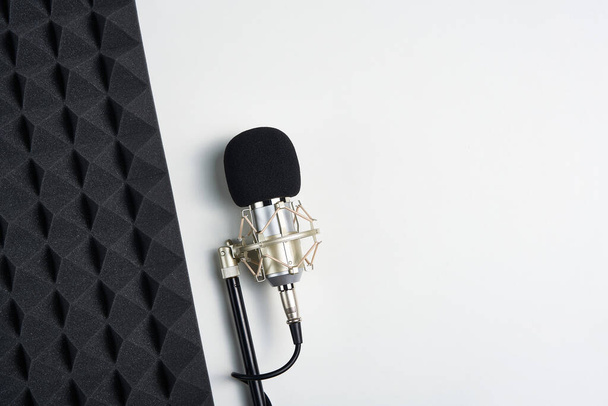 Flat lay of microphone and acoustic foam panel, over white background - Fotó, kép