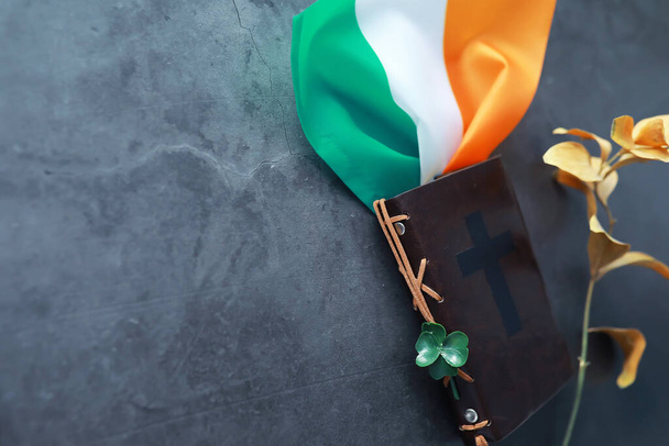 Bible vázaná v kůži na stole. Náboženská křesťanská irská oslava. Čtyřlístek jetele symbol štěstí. - Fotografie, Obrázek