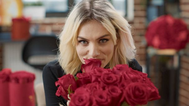 Портрет спокусливої жінки в коханні пахне червоною трояндою і дивиться на камеру насолоджуючись день валентинки
 - Фото, зображення