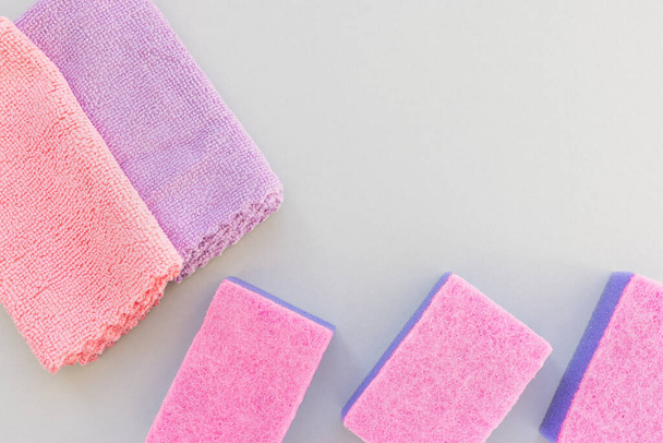 Esponjas rosadas y moradas y paño de microfibra para limpiar y espolvorear - Foto, imagen