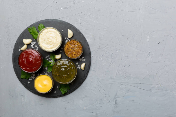 Muchas salsas y hierbas diferentes en la mesa, vista superior plana. salsas en plato, concepto saludable. - Foto, imagen