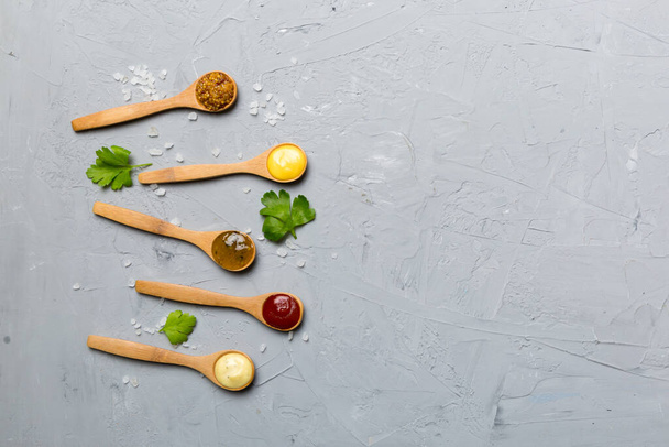 Different sauces in spoons on table background, flat lay top view. - 写真・画像