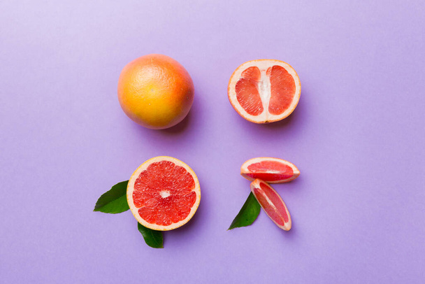 fresh Fruit grapefruit with Juicy grapefruit slices on colored background. Top view. Copy Space. creative summer concept. Half of citrus in minimal flat lay with copy space. - Zdjęcie, obraz