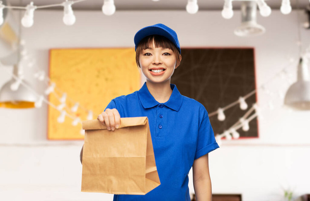 delivery woman with takeaway food in paper bag - Foto, afbeelding
