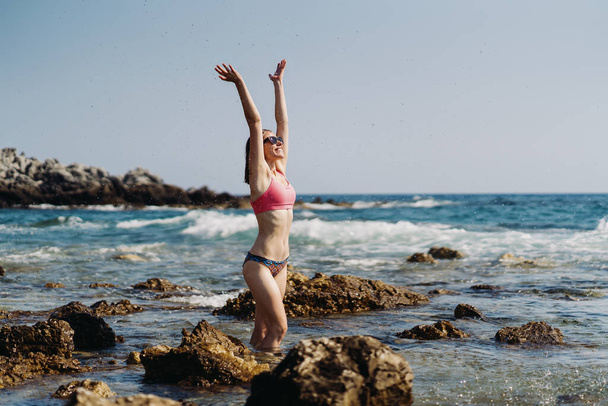 Traveler woman enjoys her vacation on sea coast - Foto, imagen