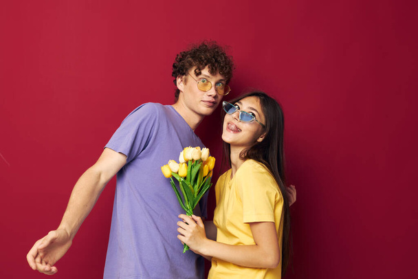 young boy and girl a bouquet of yellow flowers based friendship red background unaltered - Photo, Image