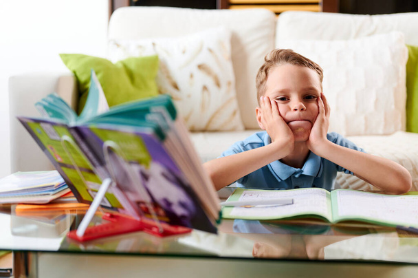 自宅で隔離に関する宿題をしている集中的な白人の学校の少年。家庭教育 - 写真・画像
