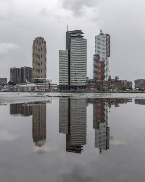 View of the Rotterdam Wilhelmina pier district from across the river with a reflection in a puddle - Photo, Image