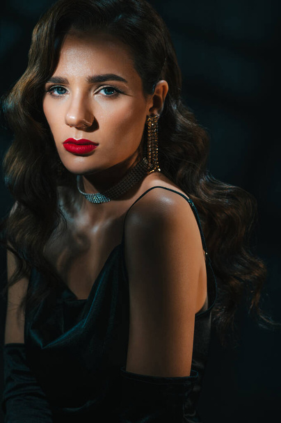 Portrait of a woman in the style of a classic retro Hollywood movie of the 1950s. Elegant young girl with a stylish hairstyle and makeup - Foto, Imagem