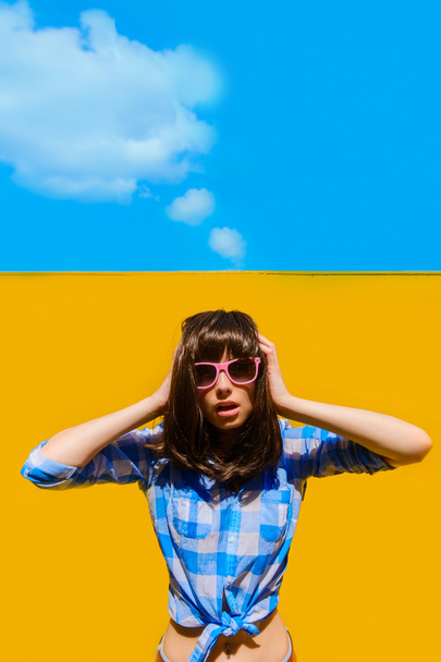 portrait of a beautiful bright blue shirt girl with glasses on a - Zdjęcie, obraz