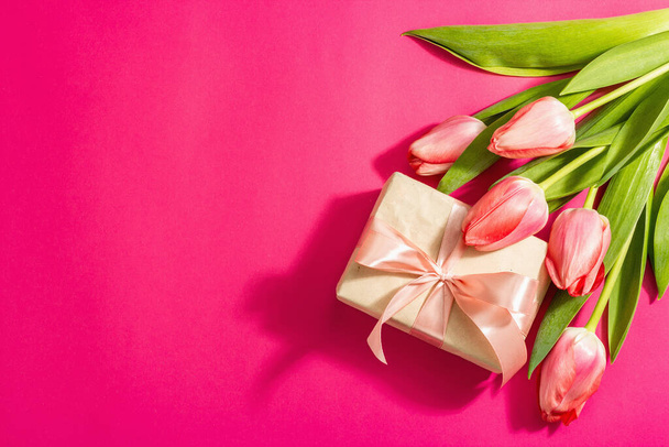 Pozdravný koncept květinové skladby, kytici růžových tulipánů a dárek. Mezinárodní den žen, Valentýna, nebo Den matek, Svatba. Purpurové pozadí, ploché ležel - Fotografie, Obrázek