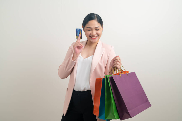 Asian woman holding shopping bag and credit card on hand with white background - Valokuva, kuva