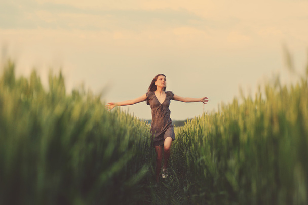 Happy woman running in the green field - Fotó, kép