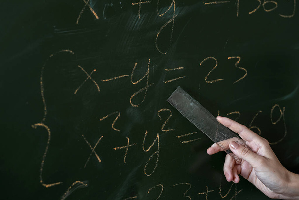 female hand writing math formulas on the classboard, close-up - Foto, afbeelding