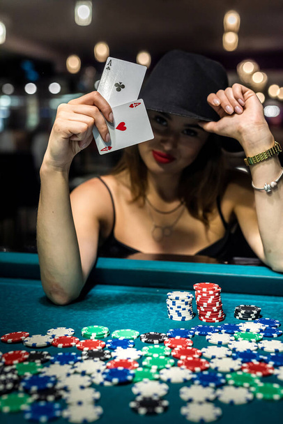 Жінка дивиться в ігрові карти в казино. чіпи і гроші, концепція азартних ігор
 - Фото, зображення