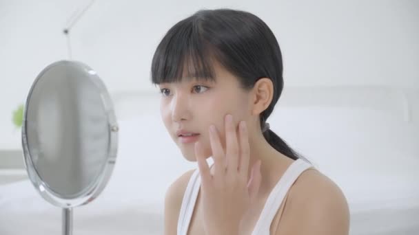 Beautiful face of young asian woman with happy smiling and touch cheek looking mirror with charming, makeup of beauty facial girl with skincare and cosmetic treatment, skin care and healthy concept. - Footage, Video