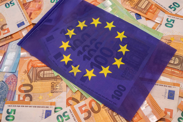 beautiful colored new euro bills on which lies the blue euro flag. The concept of the European Union - Fotoğraf, Görsel
