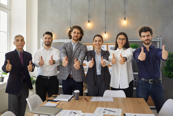 Team of happy company workers giving thumbs up after successful business meeting - Fotoğraf, Görsel