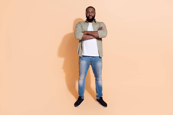 Full length photo of smart young beard guy crossed palms wear grey outfit jeans footwear isolated on beige background - Zdjęcie, obraz