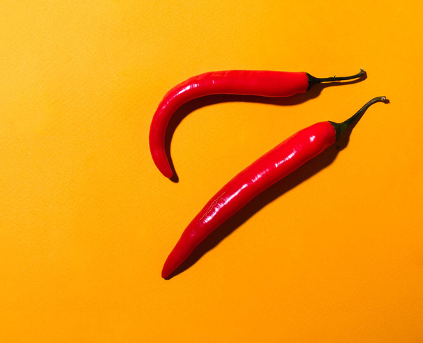rode chili peper op een gele achtergrond - Foto, afbeelding