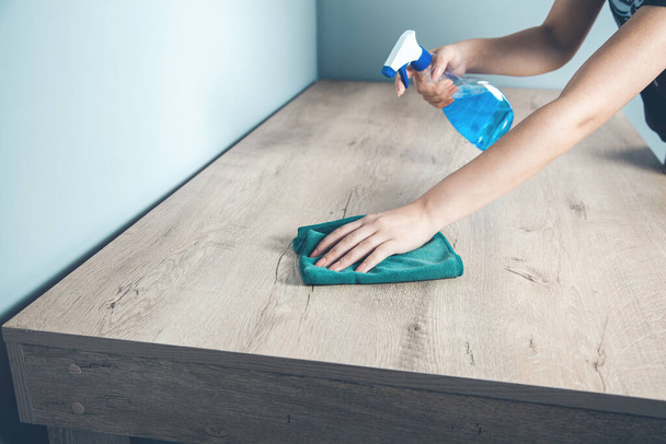 woman hand Cleaning blue spray bottle and cloth  on desk - Foto, afbeelding