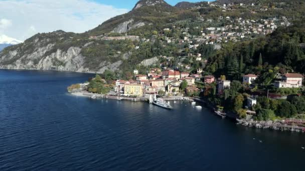 Piękny widok drona miasta Bellano wzdłuż jeziora Como brzegu ze statkiem, łodzi i gór na odległość. - Materiał filmowy, wideo