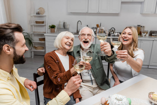 cheerful family toasting with wine glasses during easter celebration at home - Foto, imagen