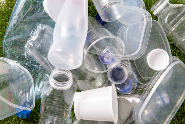 крупним планом порожні пластикові пляшки на траві
 - Фото, зображення