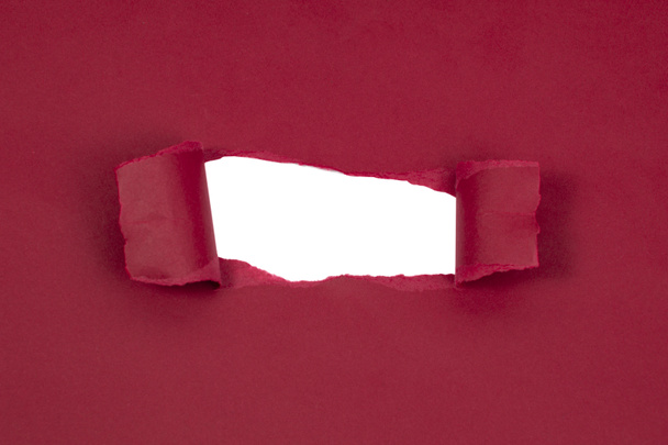 Red marsala paper damaged torn with white hole isolated copyspace for text - 写真・画像