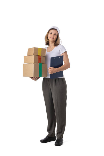 Full length portrait of delivery woman in white cap, t-shirt giving order boxes isolated on white background. Female courier step, cardboard box. Receiving package. - Foto, Imagen