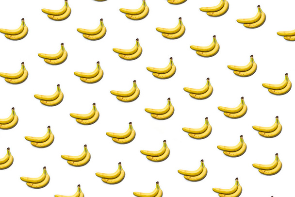 a pattern of bananas on a white background, a bunch of bananas. - Fotografie, Obrázek