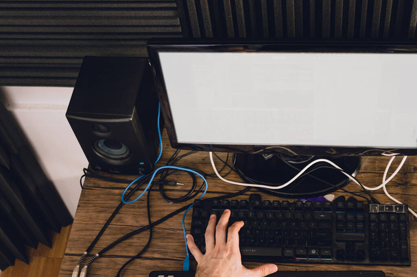 top view of caucasian hands on a computer keyboard producing music in a home studio, μουσική παραγωγή και μουσική βιομηχανία έννοια. - Φωτογραφία, εικόνα