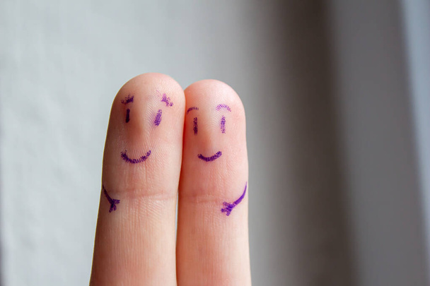 Χαμογελαστά πρόσωπα ζωγραφισμένα στα δάχτυλα. Ευτυχισμένο ζευγάρι αγκαλιές. Φωτογραφία φόντου του Αγίου Βαλεντίνου. - Φωτογραφία, εικόνα