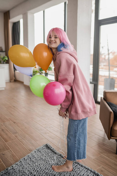 Ένα κορίτσι με φωτεινά μπαλόνια που νιώθει ευτυχισμένη και χαρούμενη. - Φωτογραφία, εικόνα