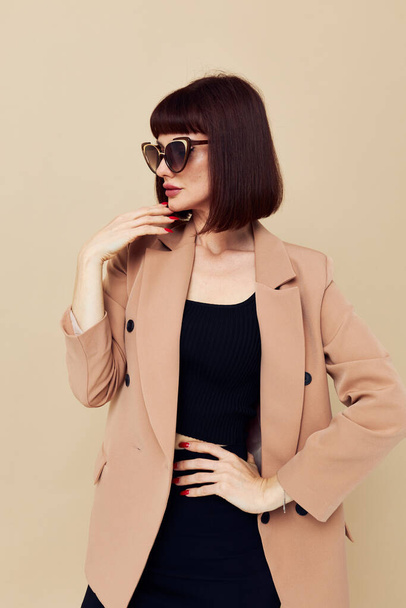 attractive woman in sunglasses short haired suit gesturing with hands isolated background - Фото, изображение
