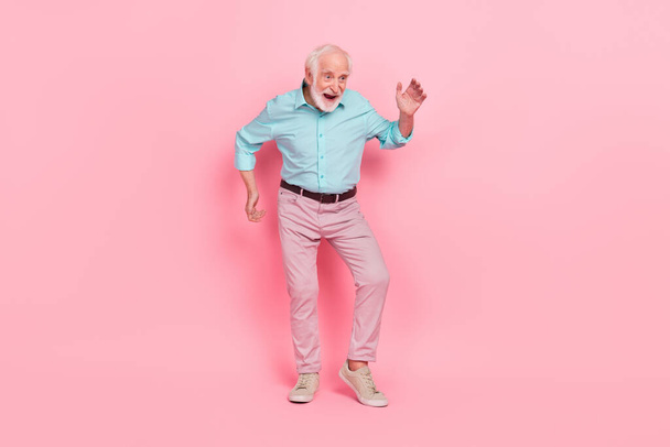 Full length photo of dynamic cool middle age man dace vintage festival hands up isolated over pastel color background - Fotó, kép