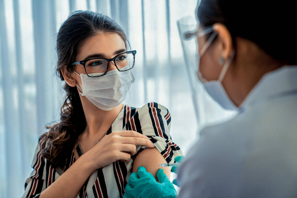 Jonge vrouw bezoekt bekwame arts in ziekenhuis voor vaccinatie - Foto, afbeelding