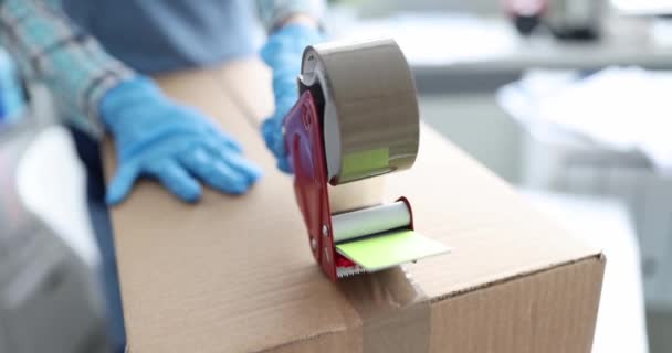 Courier works with cardboard boxes packing with tape - Footage, Video